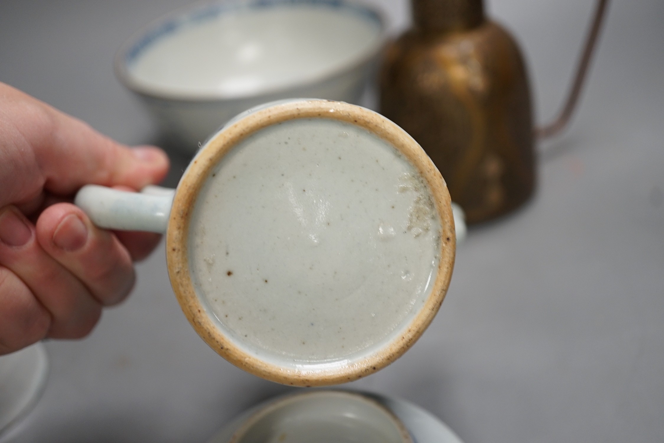 A Chinese Ming dynasty internally decorated porcelain tea bowl, an 18th century blue and white bowl, two other blue and white bowls, a similar water pot and an Islamic brass vessel